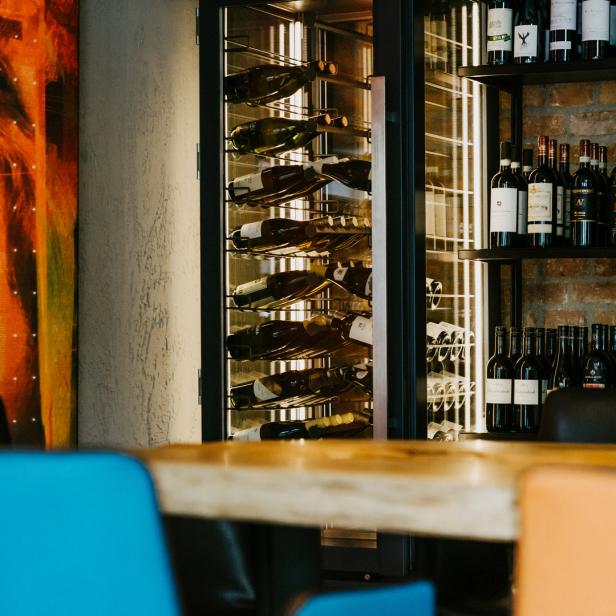 Ein Weinregal und ein Weinkühlschrank in einem Restaurant.