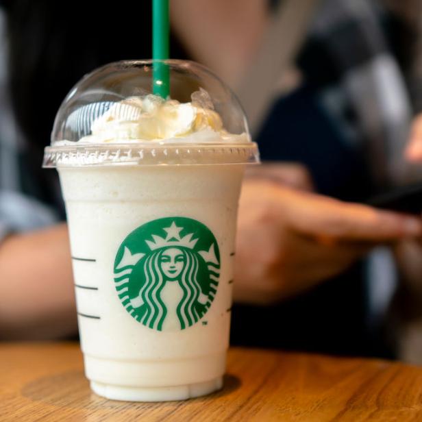 Ein Starbucks-Frappuccino mit Sahne auf einem Holztisch.