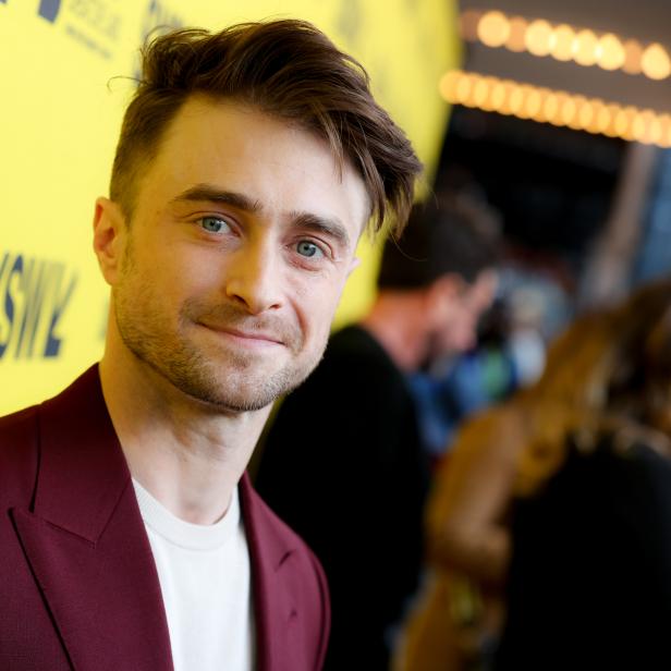 Daniel Radcliffe posiert vor einer Wand mit Sponsorenlogos.