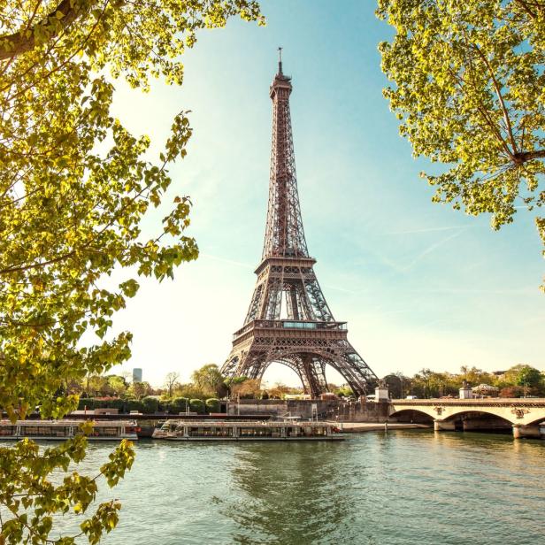 Der Eiffelturm in Paris, gesehen durch das Laub der Bäume.