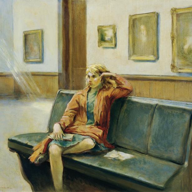 Eine junge Frau sitzt auf einer Bank in einem Museum vor mehreren Gemälden.