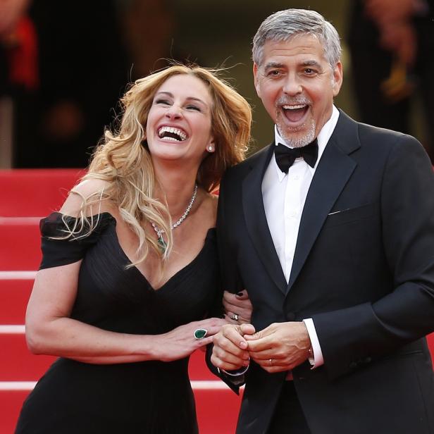 Julia Roberts und George Clooney lachen auf einem roten Teppich.