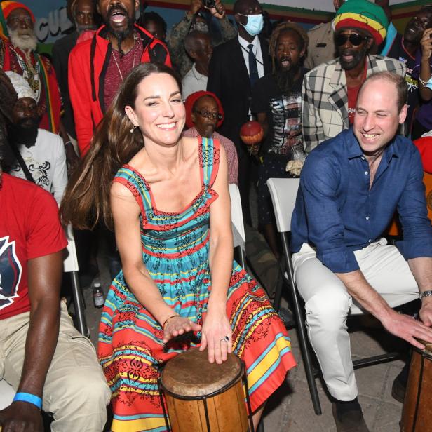 Prinz William und Prinzessin Kate spielen auf einer Trommel, umgeben von Menschen.