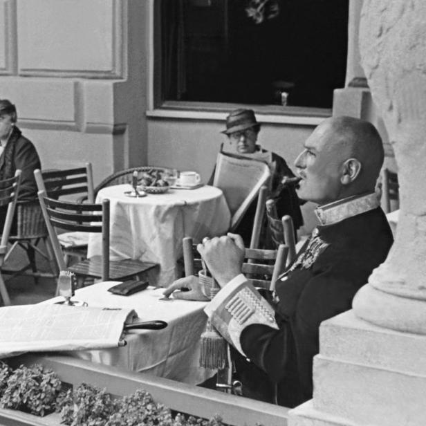 Gäste sitzen in einem Wiener Kaffeehaus im Schanigarten.