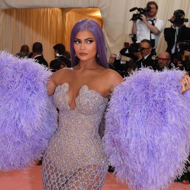 Kylie Jenner in einem mit lila Federn besetzten Kleid auf dem roten Teppich.