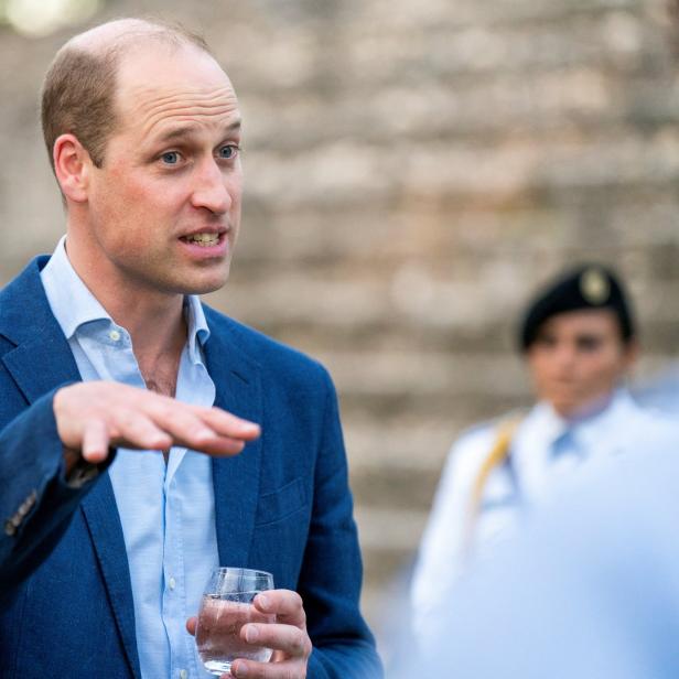 Prinz William, Herzog von Cambridge, gestikuliert mit einem Glas Wasser in der Hand.