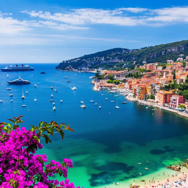 Blick auf Villefranche-sur-Mer mit zahlreichen Booten und einem Kreuzfahrtschiff im Mittelmeer.