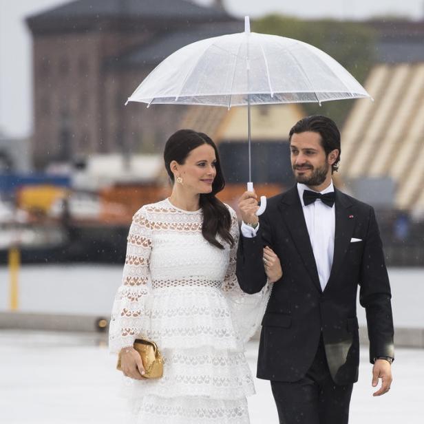 Prinz Carl Philip und Prinzessin Sofia von Schweden unter einem Regenschirm.