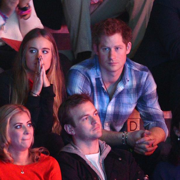 Prinz Harry sitzt mit anderen Zuschauern bei einer Veranstaltung.