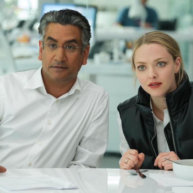 Ein Mann und Amanda Seyfried sitzen an einem Tisch in einem Büro.