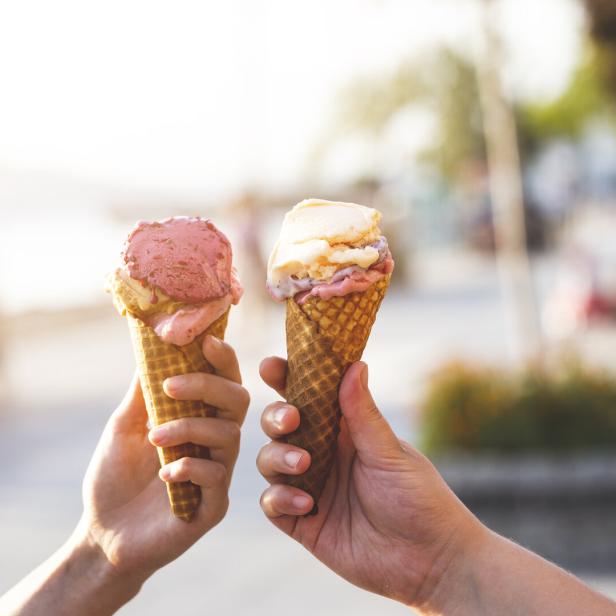 Zwei Hände halten je eine Waffel mit Eis in verschiedenen Geschmacksrichtungen.
