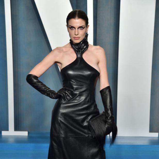 Julia Fox trägt ein schwarzes Lederkleid und lange Handschuhe auf dem roten Teppich.