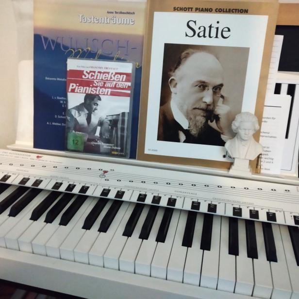 Ein Klavier mit Notenblättern, einer Film-DVD und einer kleinen Beethoven-Büste.
