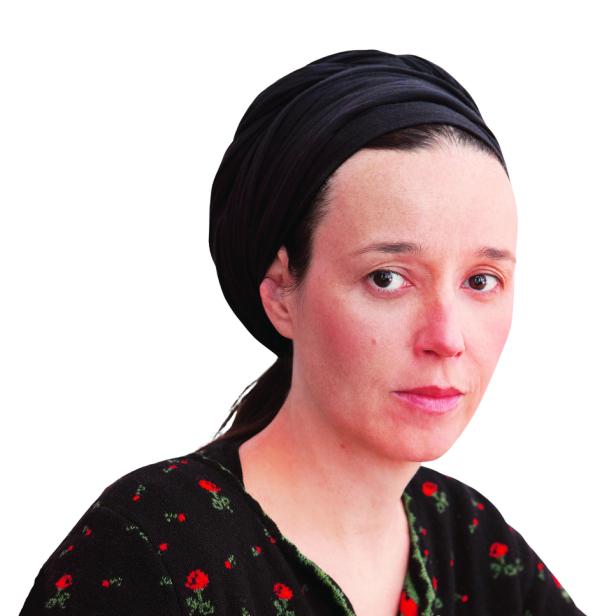 Eine Frau mit dunklem Haar und einem schwarzen Kopftuch blickt in die Kamera.