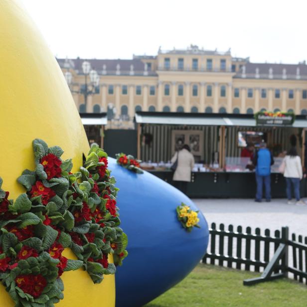 Gelbe und blaue Ostereier mit Blumen vor dem Schloss Schönbrunn.