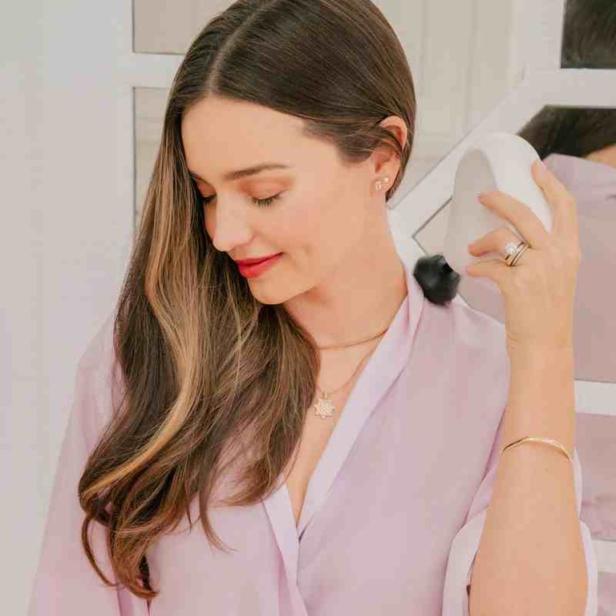 Miranda Kerr benutzt ein Gerät zur Nackenmassage.
