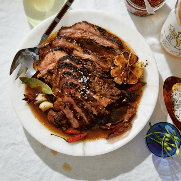 Ein Teller mit aufgeschnittenem Braten, Knoblauch und Gewürzen in Soße.