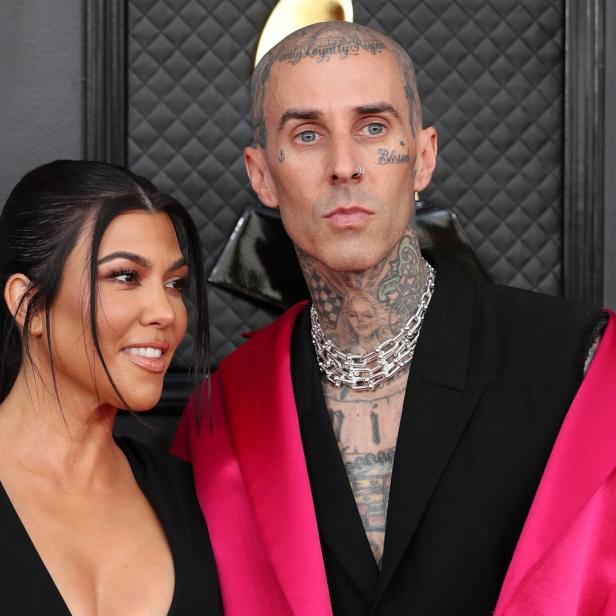 Kourtney Kardashian und Travis Barker posieren zusammen auf dem roten Teppich.