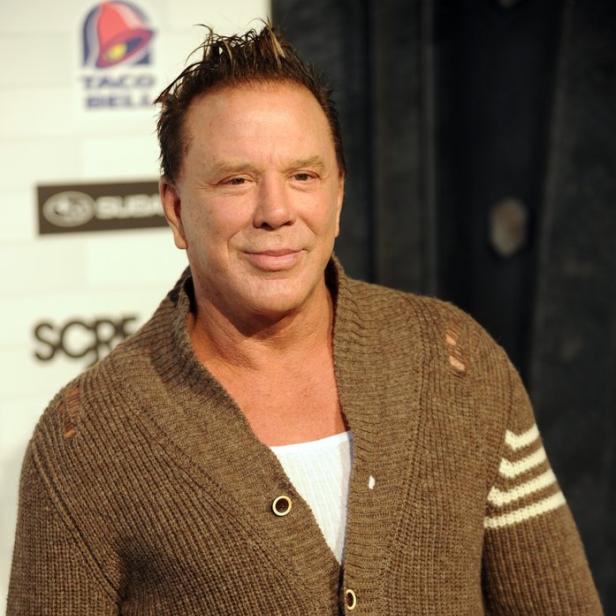 Mickey Rourke trägt eine braune Strickjacke.