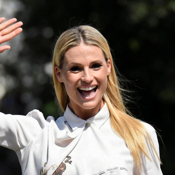Michelle Hunziker lächelt und winkt in die Kamera.