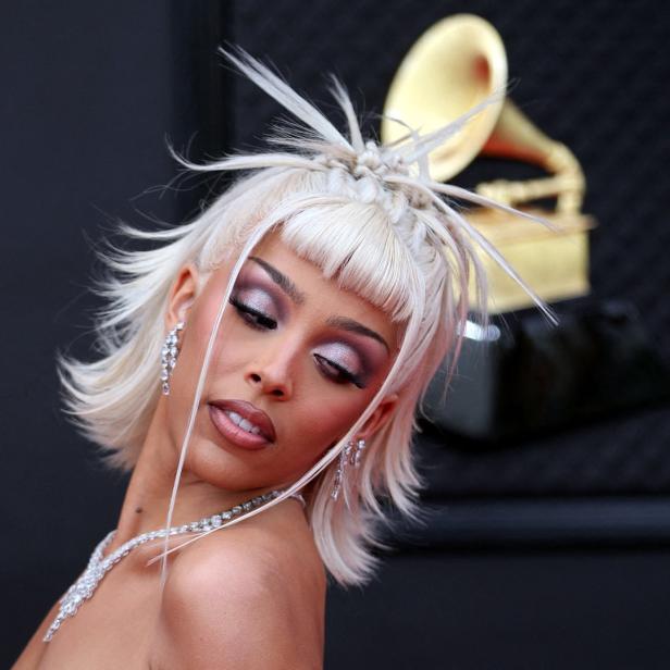Doja Cat mit platinblonden Haaren und auffälligem Make-up bei einer Preisverleihung.