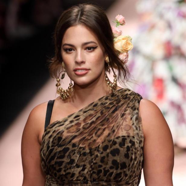 Ashley Graham trägt ein Leopardenkleid und Blumen im Haar auf dem Laufsteg.