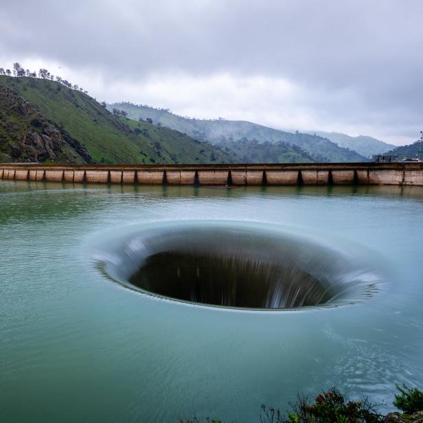 Ein Überlaufbauwerk an einem Stausee leitet Wasser ab.