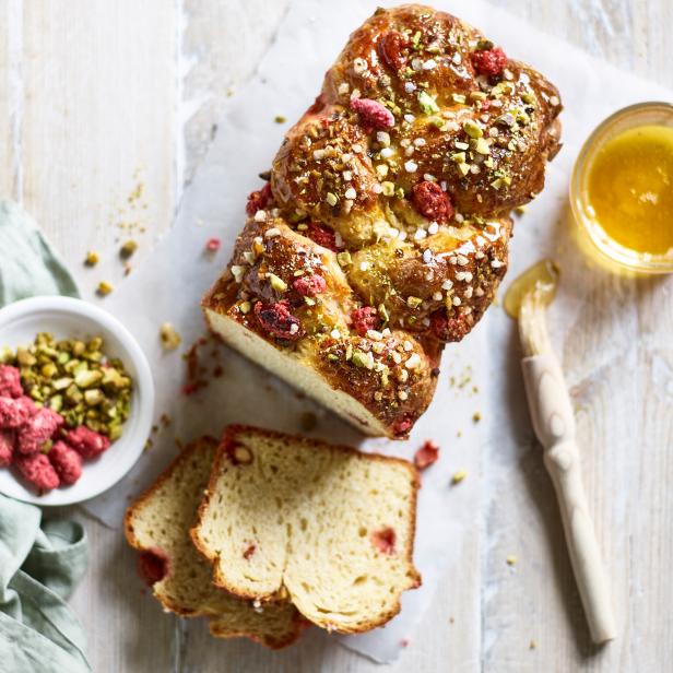 Ein süßer Hefezopf mit Pistazien und Himbeeren, dazu Honig.