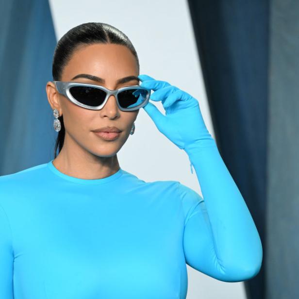 Kim Kardashian trägt eine blaue Robe und futuristische Sonnenbrille.