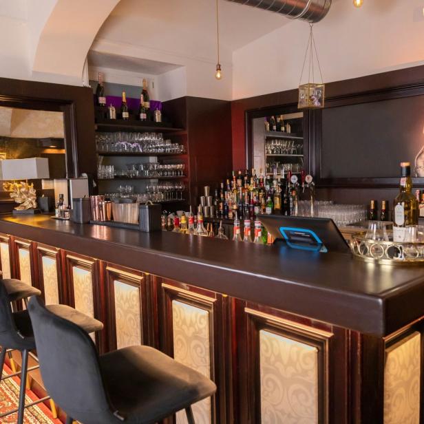 Eine Bar mit dunkler Holztheke und einem Porträt von Marilyn Monroe.