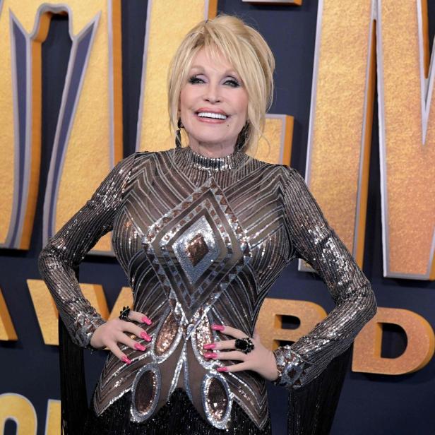 Dolly Parton posiert auf dem roten Teppich bei einer Preisverleihung.