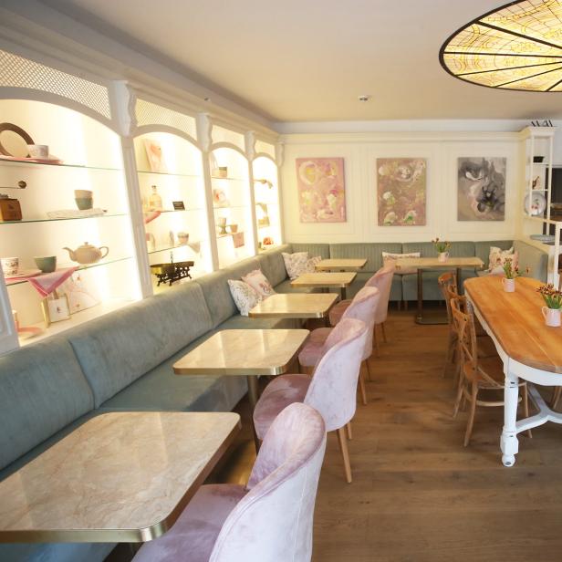 Innenansicht des Cafés „Vanillas“ mit Tischen, Stühlen und einer Tafel, die die Neueröffnung ankündigt.