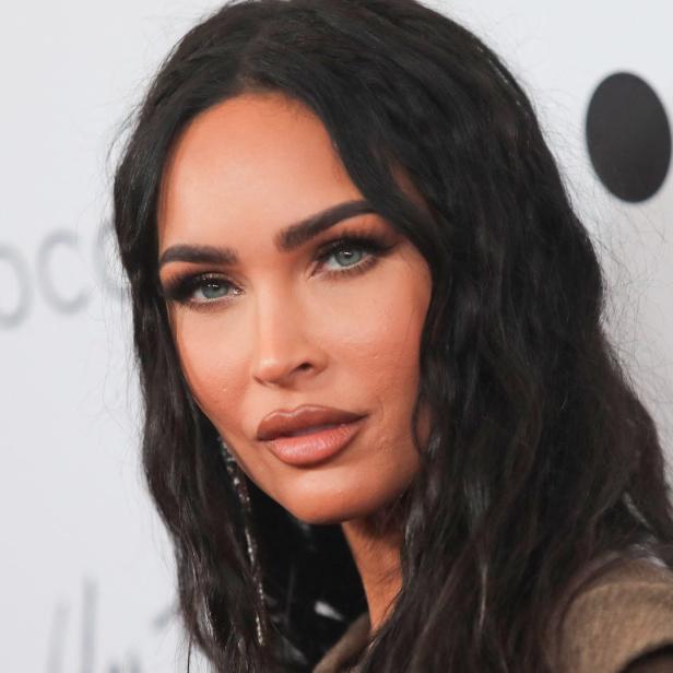 Ein Porträt von Megan Fox mit dunklen, gewellten Haaren.