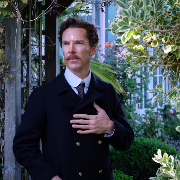 Benedict Cumberbatch posiert in einem Garten mit einem dunklen Mantel.