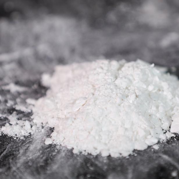 Eine weiße Substanz in Pulverform auf dunkler Oberfläche