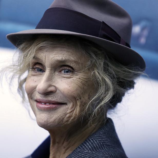 Nahaufnahme von Faye Dunaway mit Hut und grauem Blazer.