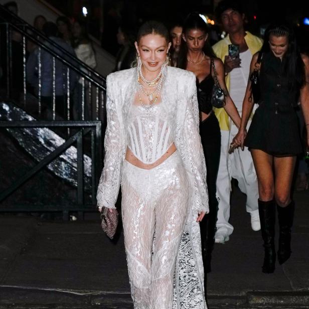 Gigi Hadid trägt ein weißes Spitzenensemble bei einem abendlichen Event.