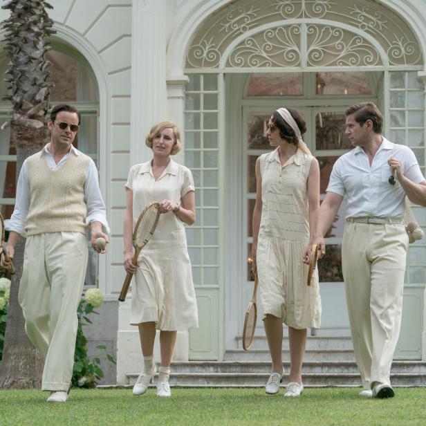 Eine Szene aus dem Film „Downton Abbey“ zeigt vier Personen mit Tennisschlägern vor einem Haus.