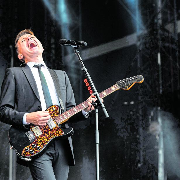 Ein Mann im Anzug spielt Gitarre und singt auf dem 27. Sziget Festival.