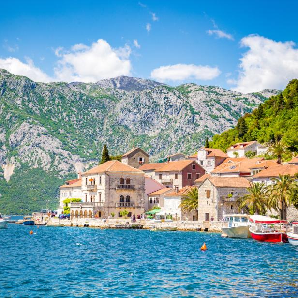 Blick auf die Küstenstadt Perast in Montenegro mit Bergen im Hintergrund.