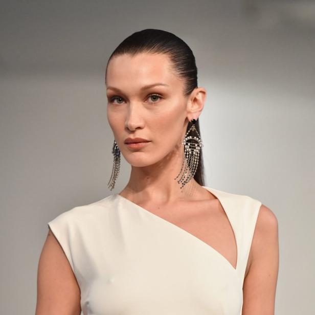 Bella Hadid trägt ein weißes Kleid und auffällige Ohrringe.