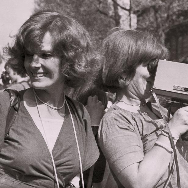 Zwei Frauen, eine lächelnd, die andere mit einem alten Sony-Camcorder.