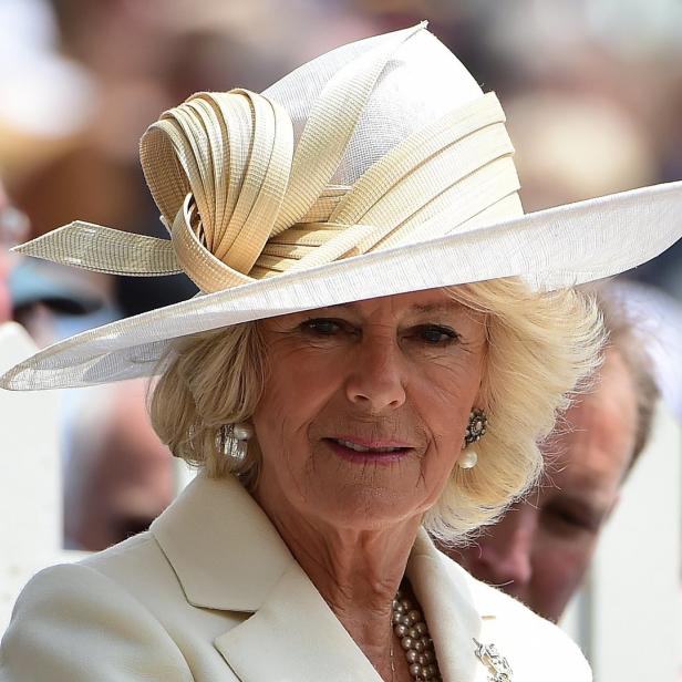 Camilla, die Königin Gemahlin, trägt einen eleganten Hut und ein cremefarbenes Kostüm.