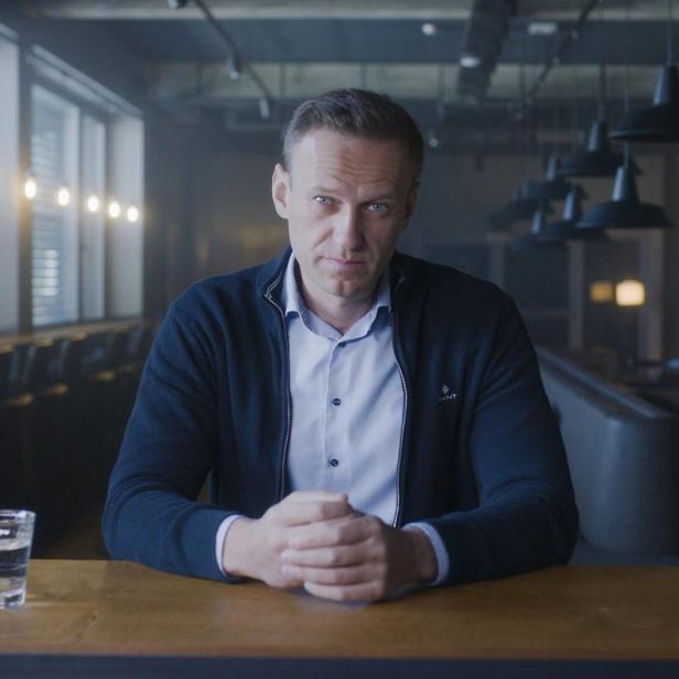 Alexei Nawalny sitzt an einem Tisch in einem Restaurant.