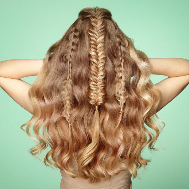 Eine Frau mit blondem, gewelltem Haar, das mit mehreren Zöpfen verziert ist.