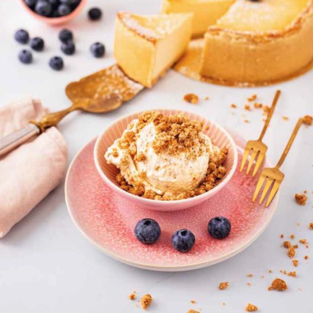 Ein Dessert mit Eis, Streuseln und Blaubeeren steht auf einem Tisch.
