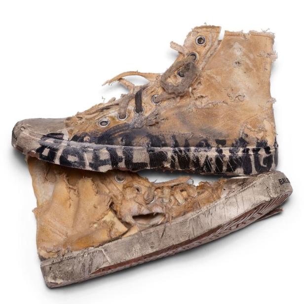 Zwei stark abgenutzte und beschädigte High-Top-Sneakers der Marke Balenciaga liegen übereinander.