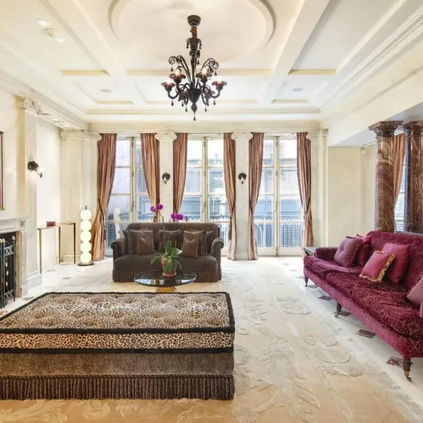 Ein luxuriöses Wohnzimmer mit Kamin, Sofas und einem großen Fenster.