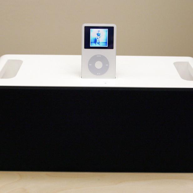 Ein weißer iPod steht auf einer Dockingstation mit Lautsprechern.