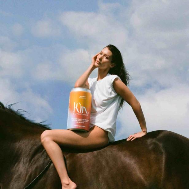 Bella Hadid reitet barfuß auf einem Pferd und hält eine Dose „Kin Euphorics“.